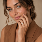 Model wearing the Amelie yellow gold solitaire ring, hand resting against the chin