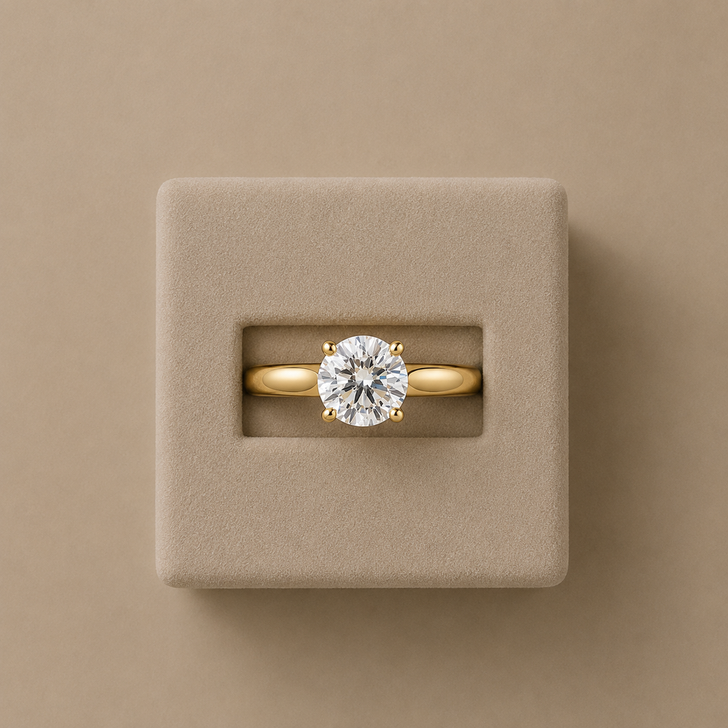 Clarisse solitaire ring set in a beige suede presentation box, photographed from above