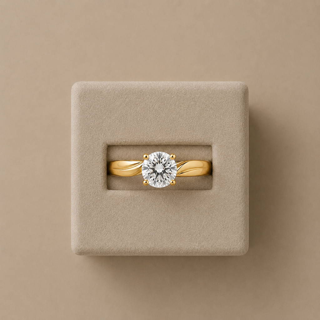 Amelie yellow gold solitaire ring set in a beige suede presentation box, photographed from above