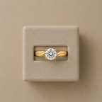 Amelie yellow gold solitaire ring set in a beige suede presentation box, photographed from above