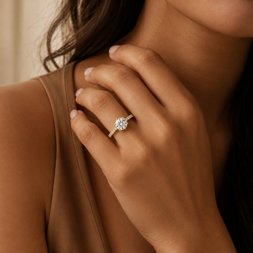 Daphne engagement ring worn on a model's hand resting against the collarbone