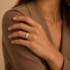 Elodie trilogy ring worn on a model's hand resting against a tan blazer