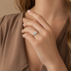 Margot trilogy ring worn on a model's hand against a tan blouse