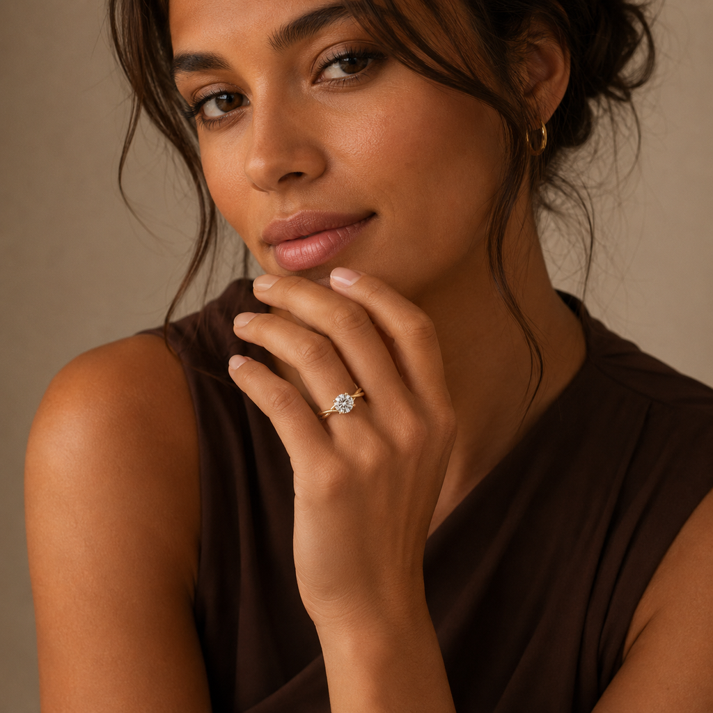 Mariette solitaire ring worn on a model's hand raised beside the face