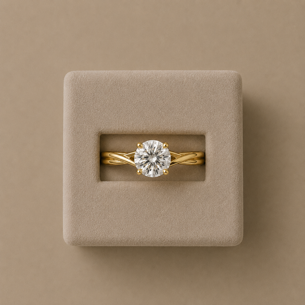 Mariette solitaire ring displayed in a beige suede ring box against a taupe backdrop