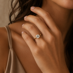 Model wearing the Solara solitaire engagement ring, hand raised near the collarbone